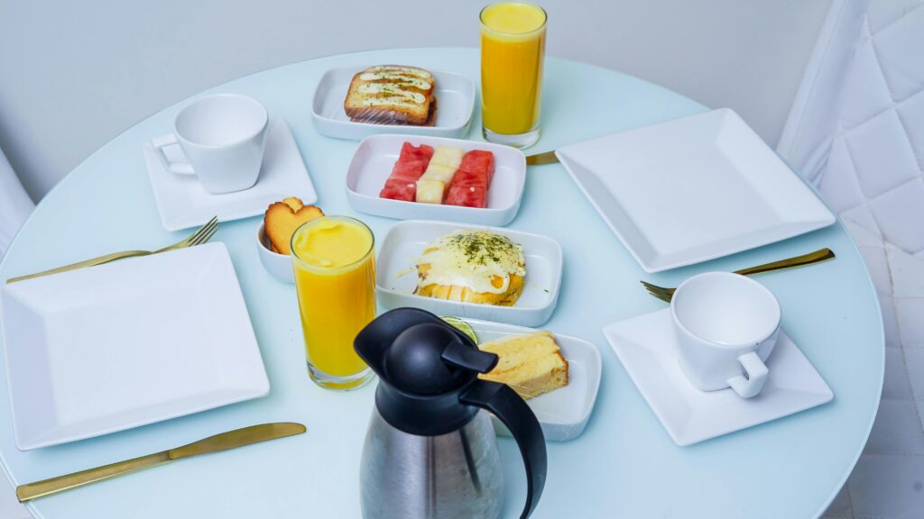 Começar o dia bem é o segredo para ter um grande dia A stylish breakfast table with fresh fruit, pastries, and juice, captured in a modern setting.