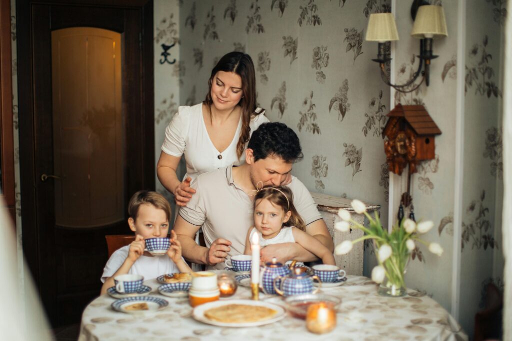 Começar o dia bem é o segredo para ter um grande dia A warm family scene capturing a joyous meal with traditional elements and close bonds.