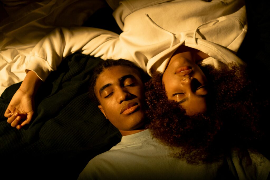A young couple peacefully resting with eyes closed, embracing tenderness and togetherness.